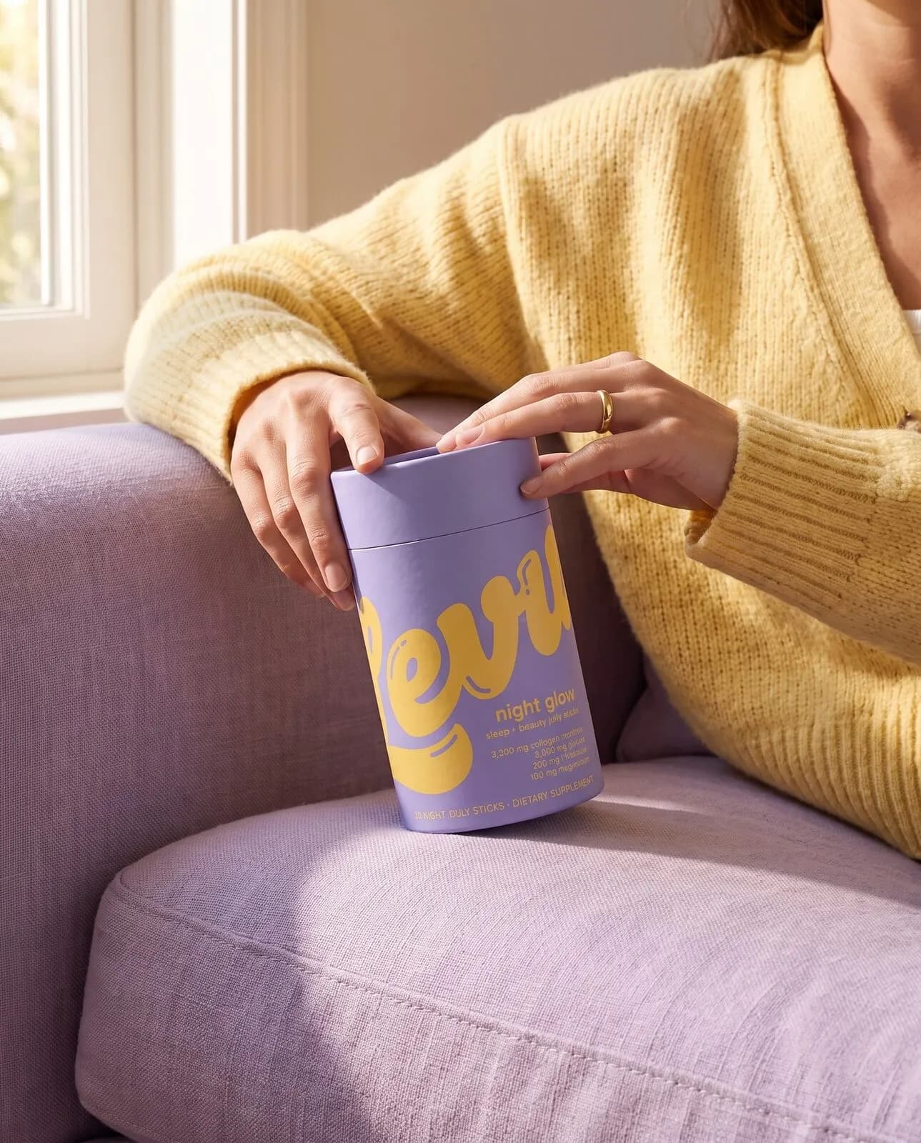 Holding a Night Glow tube on a lilac sofa