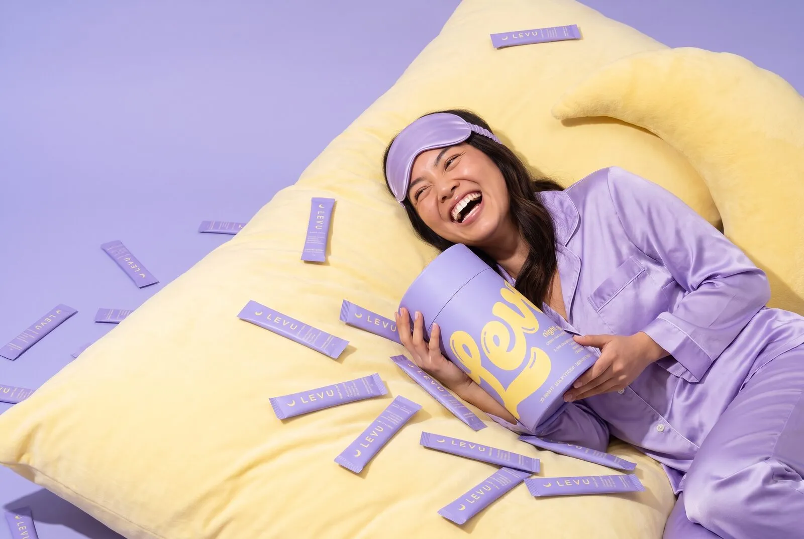 A woman in lavender pajamas hugging the Night Glow tube